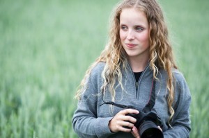 pretty young woman with an HDSLR camera outdoors shooting video